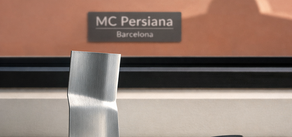 Un listón de persiana de aluminio en una repisa blanca, junto a unas tenazas, evoca el costo promedio para reparar persianas metálicas en Barcelona.