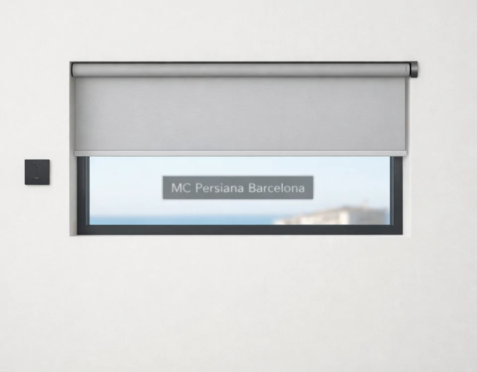 Ventana rectangular con persiana automática gris a medio bajar; cielo azul y silueta de tejados en el fondo. Donde puedo comprar persianas automaticas con instalacion incluida en Barcelona.