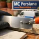Técnico elige opciones para la reparación de persianas metálicas en Barcelona, enfocándose en un listón de aluminio.