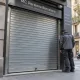 Instalador inspecciona una persiana metu00e1lica cerrada; Que sistemas de seguridad para persianas metalicas recomiendan los expertos